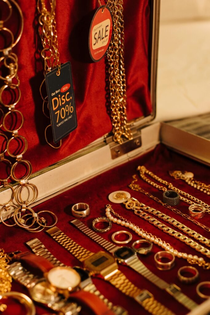Close-up of gold jewelry including chains and watches on sale with a 70% discount tag.